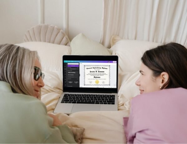 A joyful woman and her grandma browse a beautifully designed GED diploma template on a laptop while in bed, highlighting the value of a well-presented diploma in job applications.