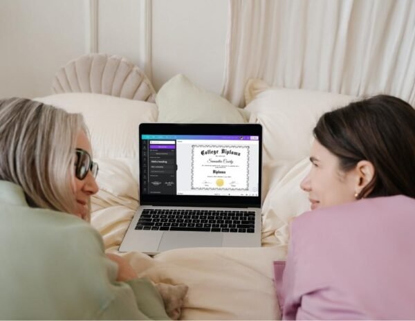 Sharing smiles and success: A happy granddaughter and her grandma together in bed, with a laptop displaying a GED graduation certificate template on Canva.