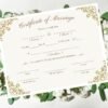 A marriage certificate displayed on a bed of vibrant green leaves against a crisp white background, available to view online.
