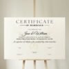 Virtual wedding certificate displayed on a rustic wooden holder at a wedding ceremony.