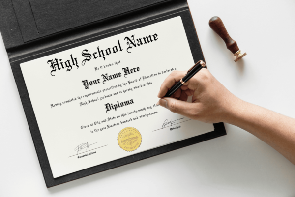 Hand signing a high school graduation diploma